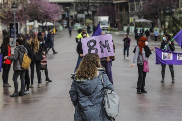 Una de las participantes sostiene una pancarta en la concentración convocada por la Assemblea Feminista en la plaza del Ayuntamiento de Valencia con motivo del 8-M