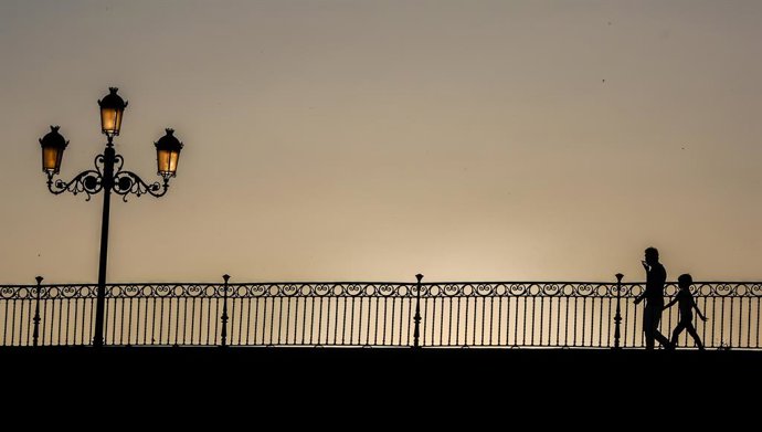 Archivo - Un home passeja amb el seu fill (Arxiu)