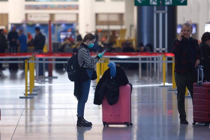 Archivo - Una turista con mascarilla y guantes en el aeropuerto de Málaga el lunes 16 de marzo de 2020