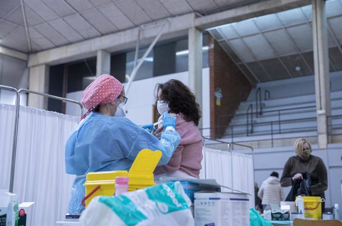 Personal sanitario durante la administración de la primera dosis de la vacuna AstraZeneca contra la Covid-19 al personal de servicio de ayuda a domicilio en las instalaciones deportiva del pabellón Sadus de la Universidad de Sevilla. En Sevilla (Andaluc