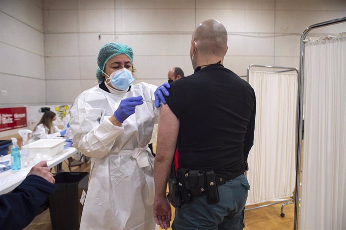 Una trabajadora sanitaria suministra la vacuna contra el Covid-19 a un agente de la Guardia Civil de Cartagena en el pabellón deportivo del Polígono Cabezo Beata de Cartagena,  Murcia, (España), a 9 de marzo de 2021.