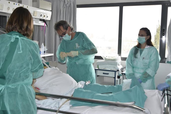 Lorenzo Pérez practica una cura a un paciente en la Unidad de Cuidados Intensivos.