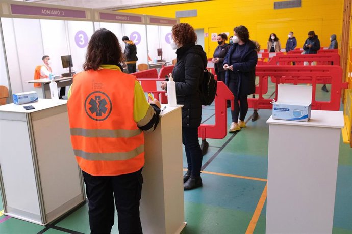 Varias personas realizan cola para que les suministren la vacuna contra la Covid-19 en el dispositivo de vacunación puesto en marcha en el polideportivo Germans Escalas. 
