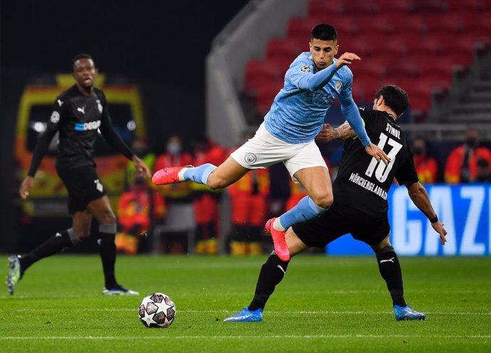 24 February 2021, Hungary, Budapest: Manchester City's Joao Cancelo (C)and Gladbach's Lars Stindl battle for the ball during the UEFAChampions League round of 16, first leg soccer match between Borussia Moenchengladbach and Manchester City. Photo: Mar