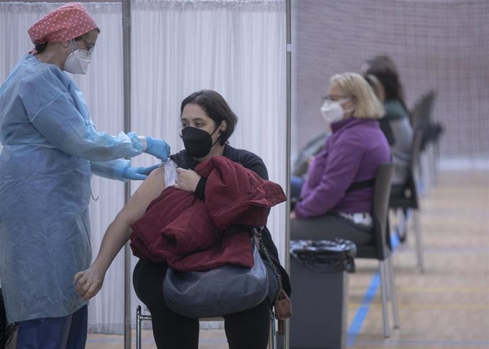 Personal sanitario durante la administración de la primera dosis de la vacuna AstraZeneca contra la Covid-19 al personal de servicio de ayuda a domicilio en las instalaciones deportiva del pabellón Sadus de la Universidad de Sevilla. En Sevilla (Andaluc