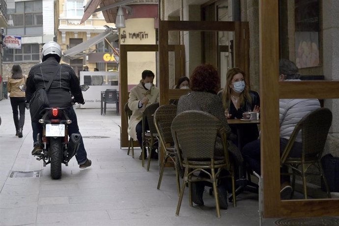 Varios comensales disfrutan en la terraza de un establecimiento durante el primer día de la reapertura del interior de los bares y restaurantes en A Coruña.