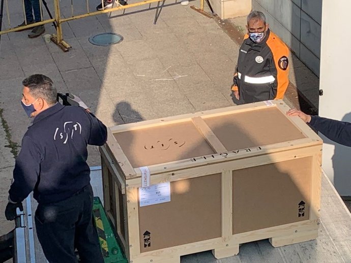 Unos operarios cargan una pieza del litigio por el arte sacro entre Lleida y Huesca.