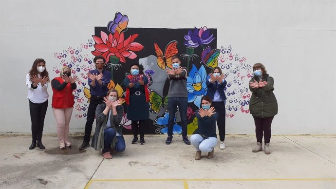 Usuarias de varios programas de Creu Rotja crean un mural en forma de mariposa en la fachada del casal de barrio Joan Alcover con motivo del Día Internacional de la Mujer.