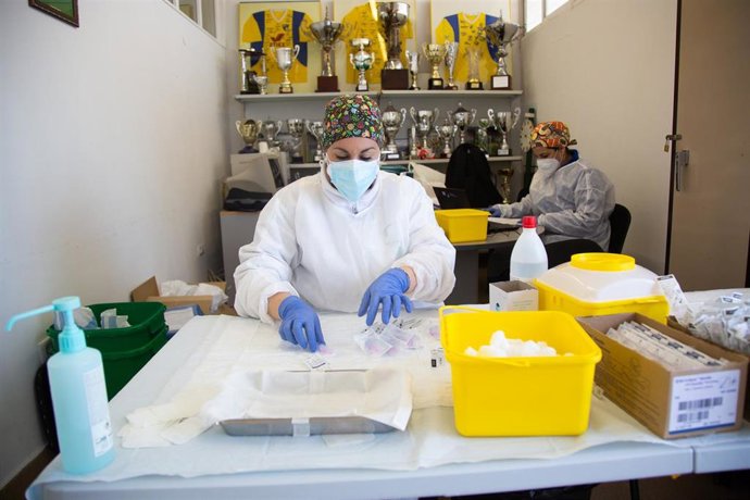 Una sanitaria prepara la dosis de la vacuna de Pfizer polideportivo de Villafranca de los Barros.