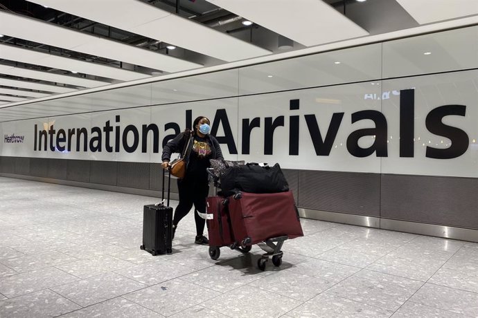 Archivo - 18 January 2021, United Kingdom, London: A passenger pushes a trolley through the arrival hall of Terminal 5 at London's Heathrow Airport, passengers arriving from anywhere outside the UK must have proof of a negative coronavirus test and self