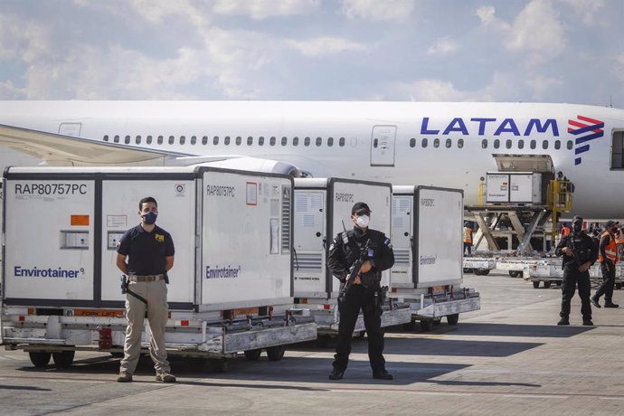 Archivo - 31 January 2021, Chile, Santiago: Security guards protect containers with two million doses of coronavirus vaccine made by Chinese pharmaceutical company Sinovac Biotech at Arturo Merino Benitez Airport. Photo: Sebastian Beltran Gaete/Agencia 