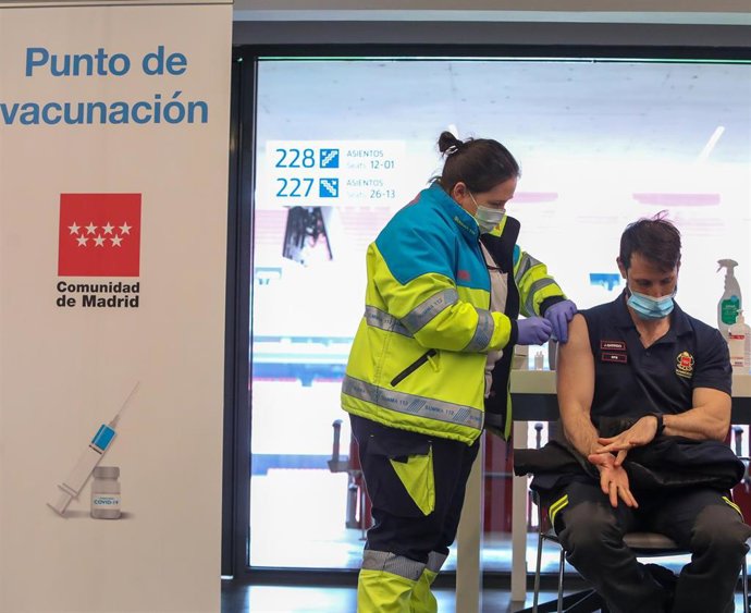 Una sanitaria vacuna a un bombero de la Comunidad de Madrid en el punto de vacunación contra el Covid-19 puesto en marcha en el Estadio Wanda Metropolitano el primer día de su funcionamiento, en Madrid (España), a 25 de febrero de 2021.