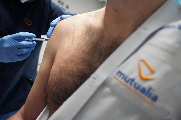 Un sanitario vacuna a un médico de la clínica contra el Covid-19