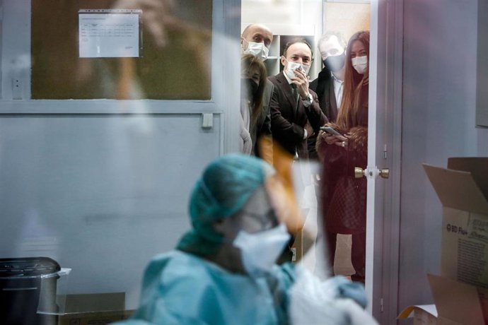 El jefe de Gobierno de Andorra, con los ministros de Salud y de Justícia e Interior observando una profesional preparando dosis en el centro de administración de vacunas