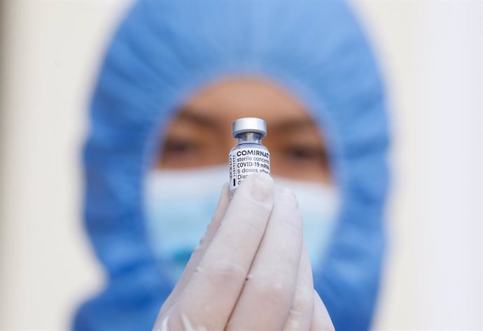 HANDOUT - 08 March 2021, Peru, Lima: A health worker in protective gear holds a vial containing the Pfizer-Biontech COVID-19 vaccine during a vaccination campaign. Photo: Karel Navarro/Minsa/dpa - ACHTUNG: Nur zur redaktionellen Verwendung und nur mit v