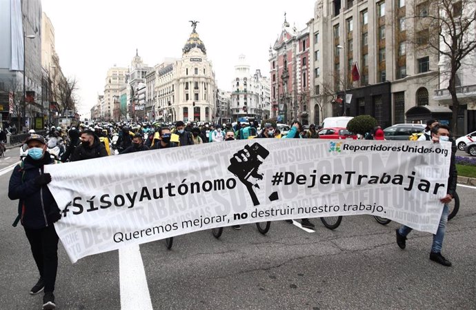 Varias personas sostienen una pancarta donde se lee "#SíSoyAutonomo #DejenTrabajar", durante una manifestación de repartidores a domicilio, en Madrid (España)