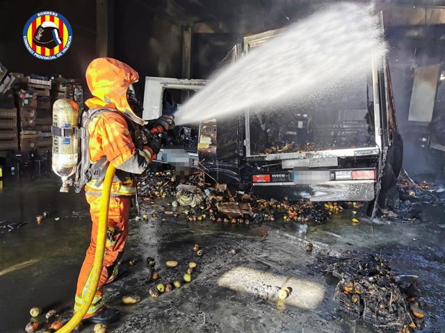 Bomberos apagando el incendio en la nave de Silla