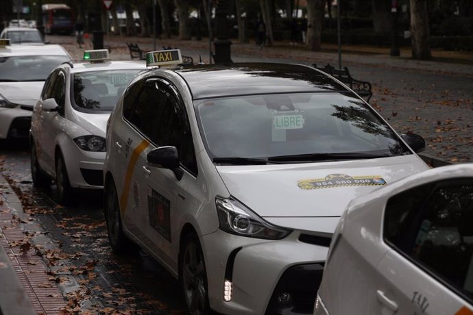 Archivo - Varios taxis a la espera de clientes, guardan turno en una parada