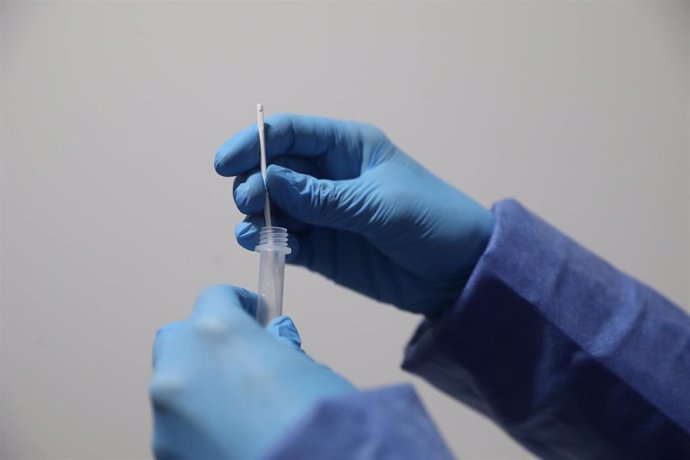 Un sanitario sostiene una probeta tras realizar un test de antígenos