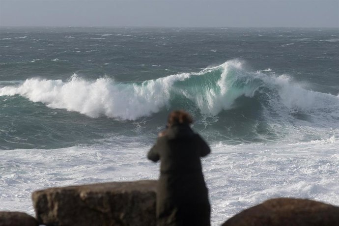Archivo - Una persona graba el oleaje en la zona del Acuarium Finisterrae, en A Coruña, Galicia (España), a 30 de enero de 2021. Este sábado Galicia está afectada por una borrasca denominada 'Justine' que ha dejado cielos cubiertos con precipitaciones, 