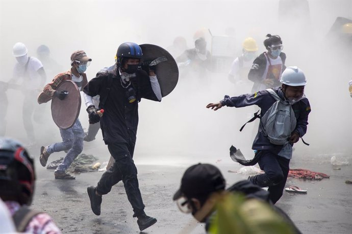 Un grupo de manifestantes se dispersa después de que la Policía lance gas lacrimógeno durante una manifestación contra el golpe militar en Rangún, la ciudad más poblada de Birmania.