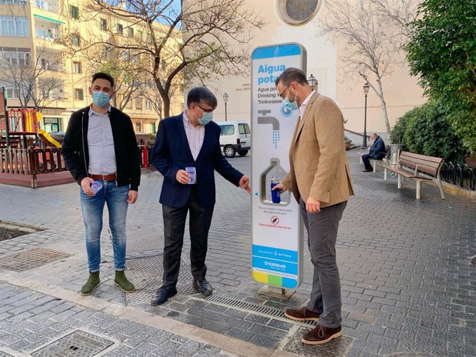 El alcalde de Palma, José Hila, y el presidente de la Empresa Municipal de Aguas y Alcantarillado (Emaya), Ramón Perpiny, rellenando una botella en la fuente de agua potable de la Plaza Santa Pagesa.