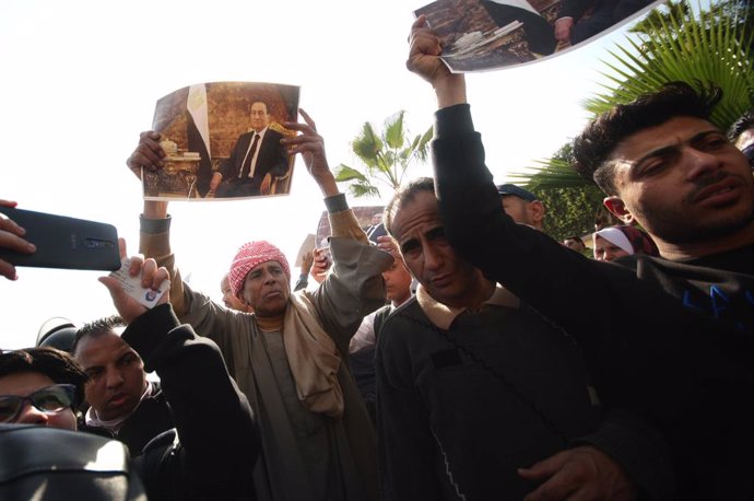 Archivo - 26 February 2020, Egypt, Cairo: Supporters of Egyptian former President Hosni Mubarak grieve outside the cemetery in Cairo's Heliopolis suburb where Mubarak has been buried after his military funeral. Mubarak, who ruled Egypt for three decades