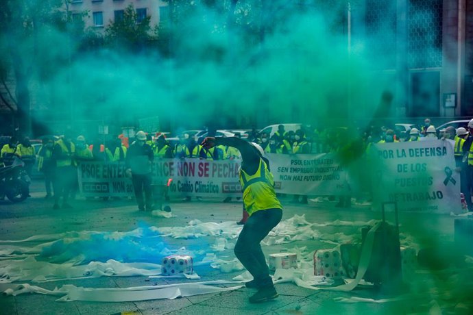 Trabajadores de la factoría pontevedresa de ENCE se concentran con chalecos amarillos, pancartas, tirando rollos de papel higiénico y rodeados de humo verde en las inmediaciones del Ministerio de Transición Ecológica en Madrid (España), a 12 de marzo de