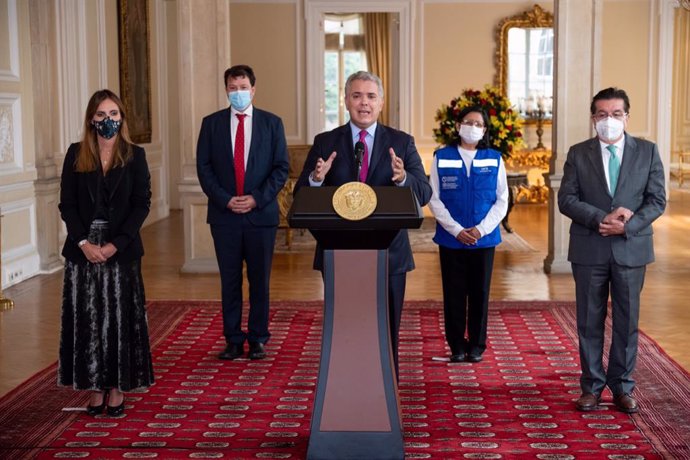 HANDOUT - 01 March 2021, Colombia, Bogota: President of Colombia Ivan Duque (C) delivers a speech after the arrival of the Pfizer/BioNTech coronavirus vaccine shipment. Colombia on Monday took delivery of 117,000 doses of vaccine from the international 