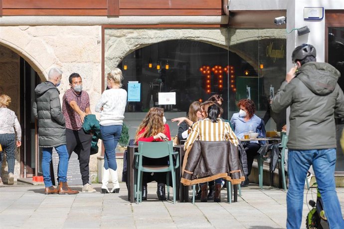 Varias personas en la terraza de un restaurante durante el primer día de la apertura parcial de la hostelería en Vigo, Pontevedra, Galicia (España), a 26 de febrero de 2021. La Xunta de Galicia reabre desde hoy parcialmente la hostelería y la movilidad 