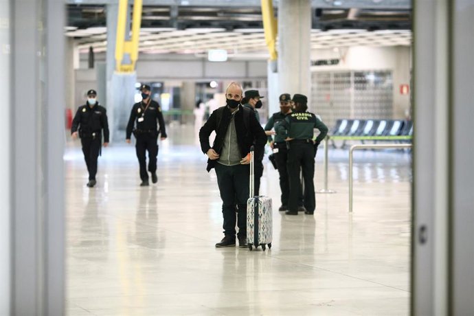 Archivo - Un pasajero con maleta junto a agentes de la Guardia Civil en la terminal T4 del Aeropuerto de Madrid-Barajas Adolfo Suárez, en Madrid (España), a 23 de noviembre de 2020. 