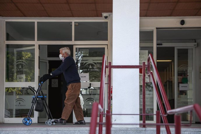 Un hombre mayor pasea con un andador a las puertas de un centro residencial en Sevilla.