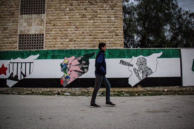 Un joven pasea ante un ural en Idlib