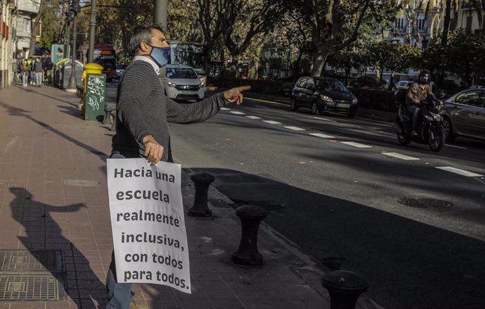 Archivo - Un hombre porta un cartel reivindicativo durante el día en que autobuses escolares de colegios concertados recorren la ciudad con lazos naranja en protesta contra la Ley Celaá, que se vota hoy en el Congreso de los Diputados, en Valencia, Co