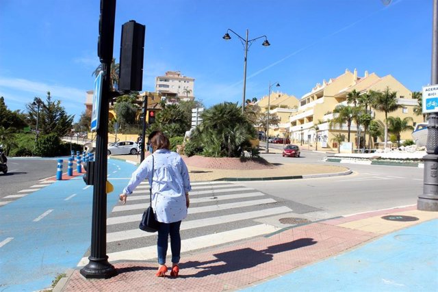 Una ciudadana de Estepona utiliza el nuevo dispositivo en el semáforo sin tocarlo