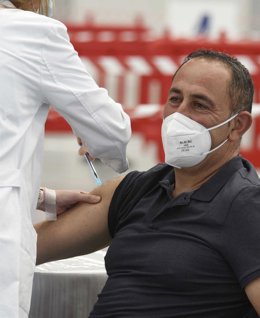 Una sanitaria vacuna a una hombre.