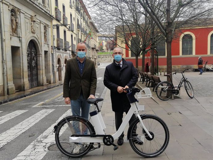Fermín Alonso y Enrique Maya con una de las bicicletas del nuevo servicio del Ayuntamiento de Pamplona