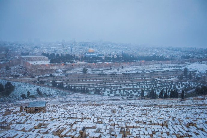 18 February 2021, ---, Jerusalem: A general view of buildings covered with snow outside walls of the Old City of Jerusalem during heavy snowfalls. Photo: Ilia Yefimovich/dpa