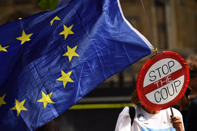 Archivo - 04 September 2019, England, London: A pro-European demonstrator waves an EU flag and a sign in front of the parliament building in Westminster. Photo: Dominic Lipinski/PA Wire/dpa