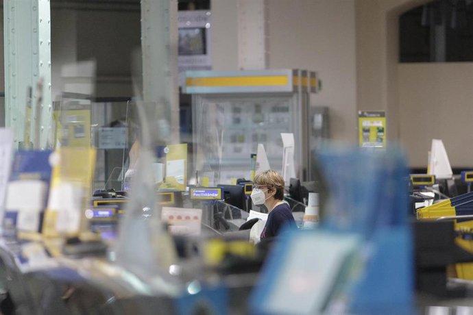 Archivo - Un trabajador de Correos durante su jornada laboral en la Oficina de Cibeles.