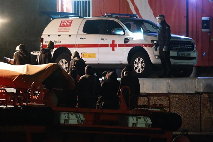 Archivo - Trabajadores de Cruz Roja Española ayudan a un grupo de inmigrantes durante su llegada al Muelle de Gran Tarajal, Fuerteventura