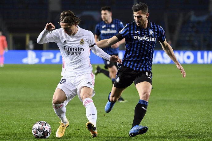 24 February 2021, Italy, Bergamo: Real Madrid's Luka Modric (L) and Atalanta's Cristian Romero battle for the ball during the UEFAChampions League round of 16 first leg soccer match between Real Madrid and Atalanta BC at Gewiss Stadium. Photo: Marco Al