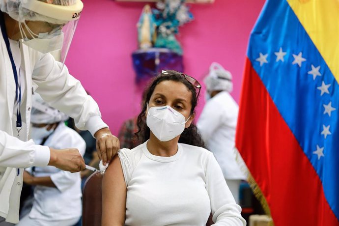 20 February 2021, Venezuela, Caracas: A woman receives a dose of the Russian COVID-19 vaccine Sputnik V in a public hospital. Photo: Jesus Vargas/dpa