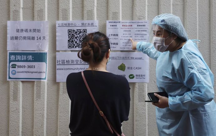 Archivo - Personal médico de Hong Kong da indicaciones a quienes se acercan a sus instalaciones para someterse a una prueba de COVID-19.