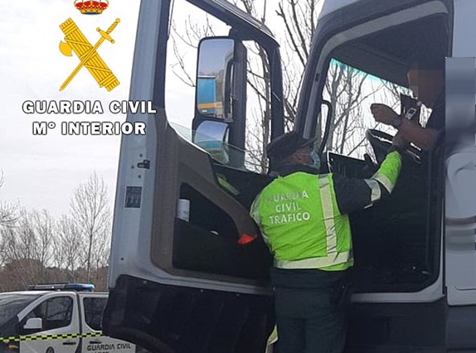 Un agente de la Guardia Civil realiza la prueba de alcoholemia al conductor de un camión.