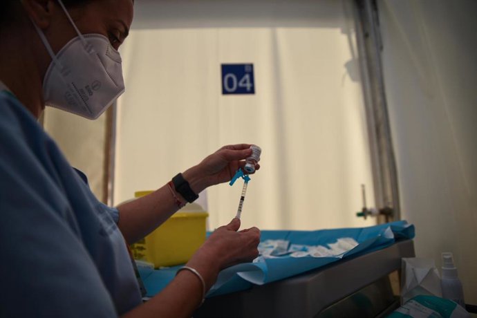 Una profesional sanitaria sostiene una jeringuilla y un vial con la vacuna contra la Covid-19 de AstraZeneca en el Hospital de campaña de La Fe, en Valencia. 