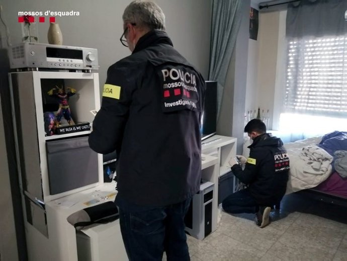Dos agentes durante el registro en una de las viviendas del detenido.