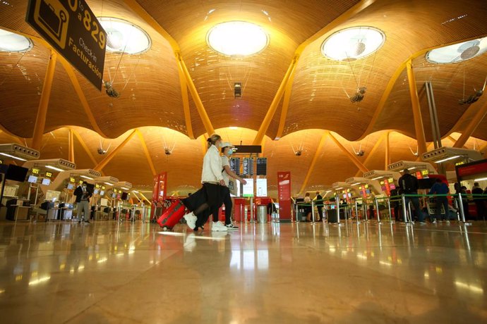 Dos personas caminan con su equipaje en la Terminal T4 del Aeropuerto Adolfo Suárez Madrid-Barajas.
