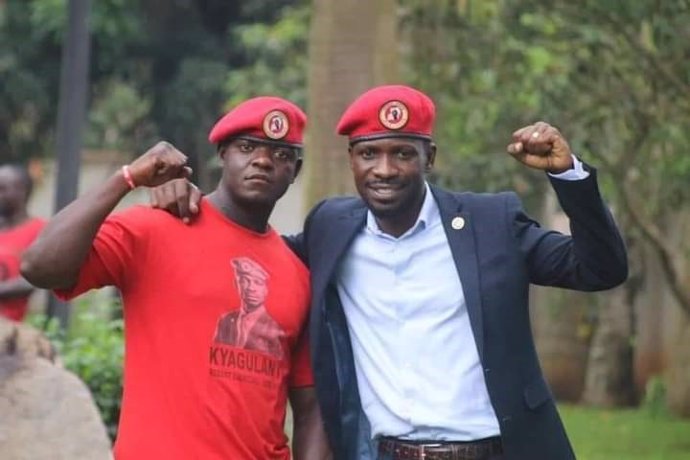 Archivo - El guardaespaldas Francis Sentenza Kalibala (izq) y el candidato opositor ugandés Robert Kyagulanyi, Bobi Wine