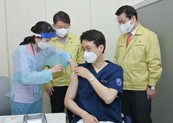 Un sanitario recibe una dosis de la vacuna en Corea del Sur.